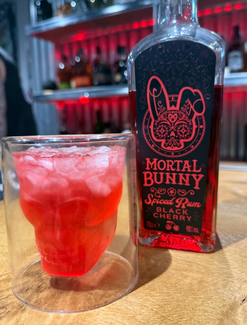 Black Cherry Rum bottle beside a red drink served over ice