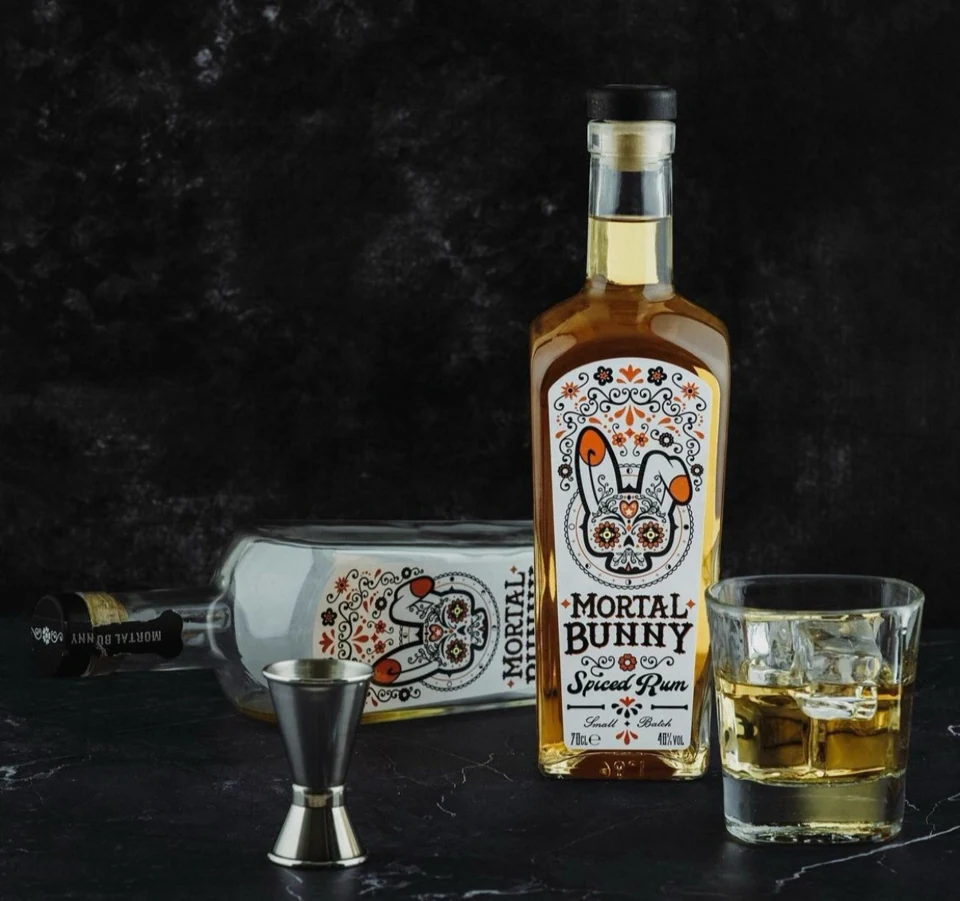 Original Spiced Rum bottles with a measure and a glass over ice